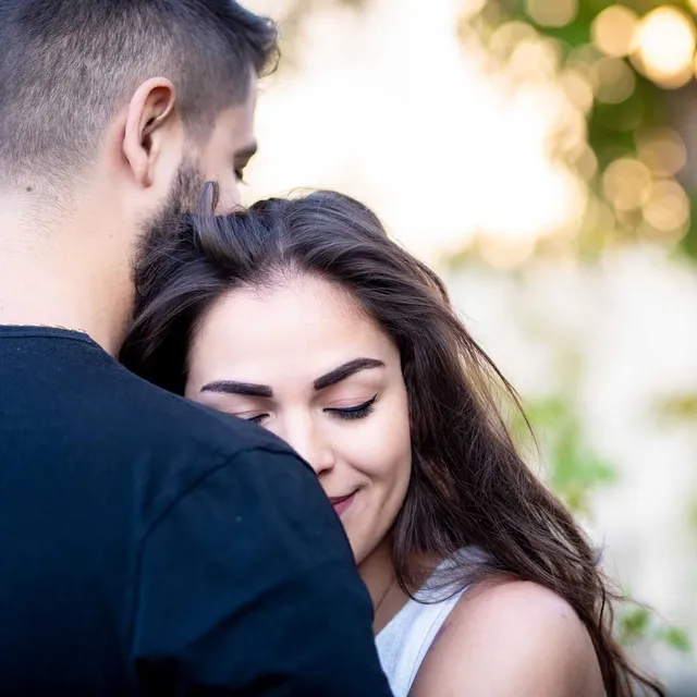 cover galerie Un couple s'embrasse tendrement dans un environnement extérieur baigné de lumière dorée.