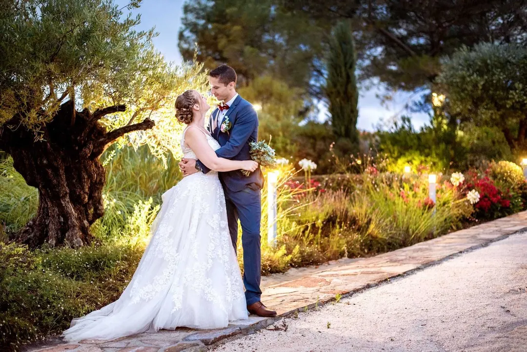 Mariés sous un chêne centenaire, l'échange tendre d'un baiser illuminé par la nuit.