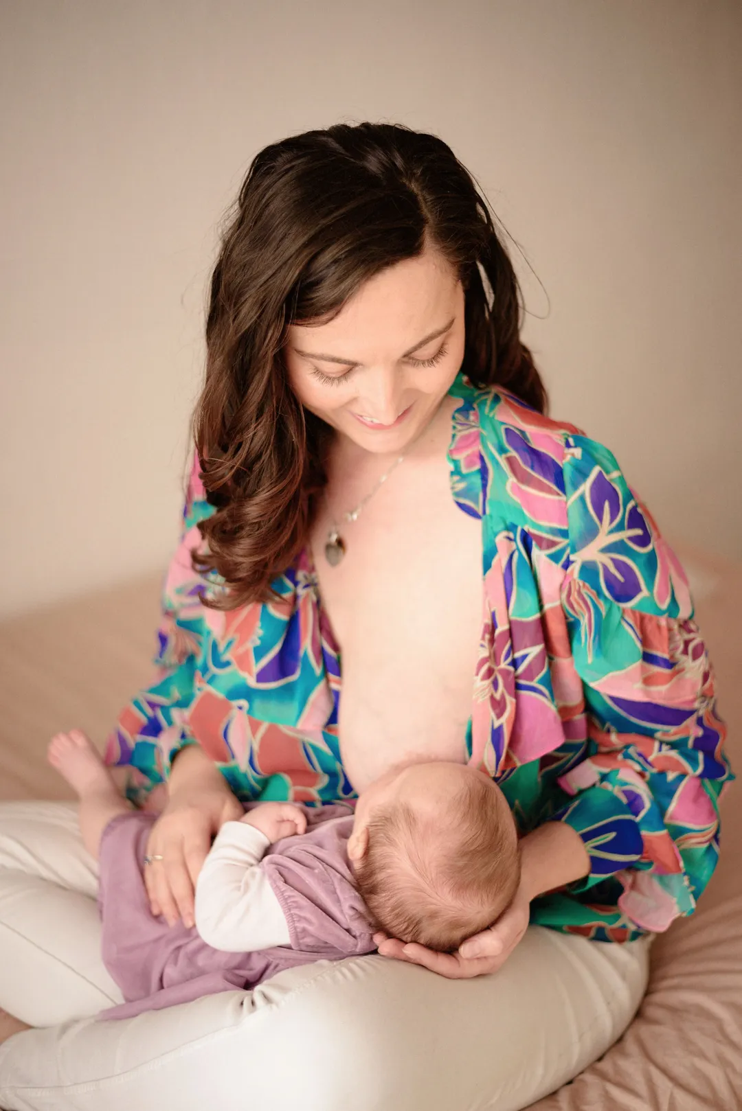 Mère et bébé, moment de tendresse et de contact peau à peau sur un lit moelleux.