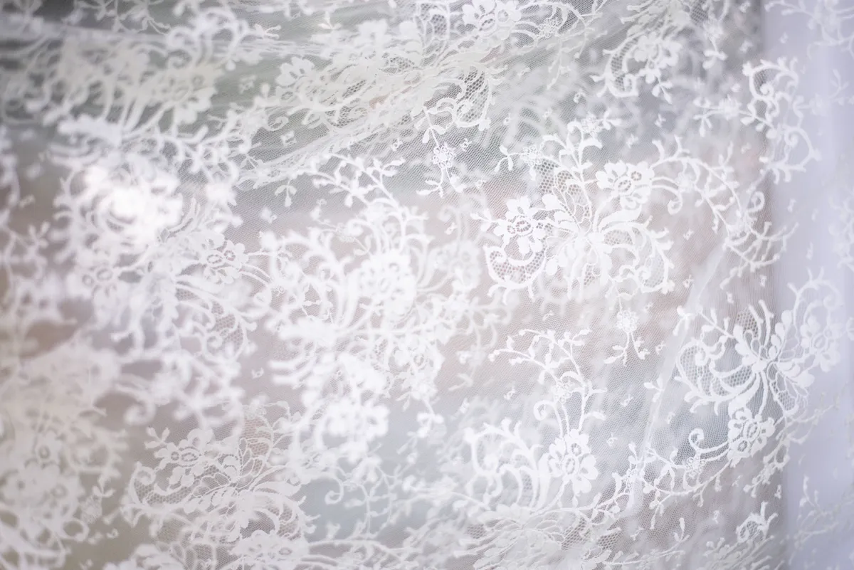 Dentelle blanche ornée d'un motif floraux complexes.