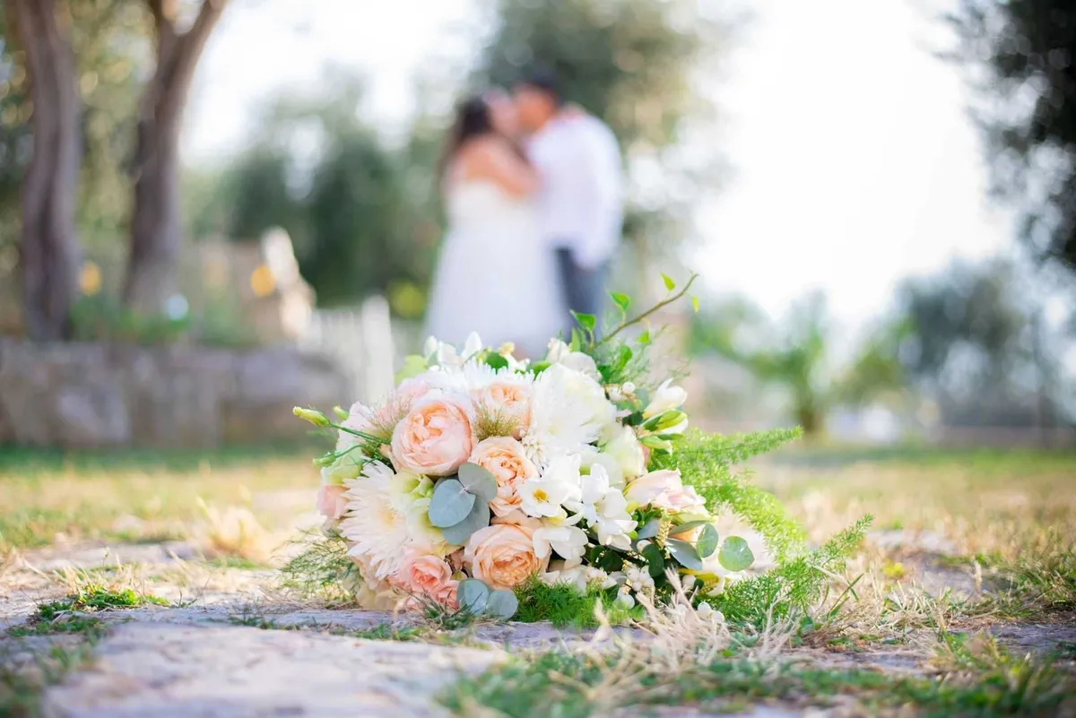 Un bouquet de fleurs blanches et roses se pose sur un chemin de terre, témoignant de l'amour et de la tendresse des mariés.