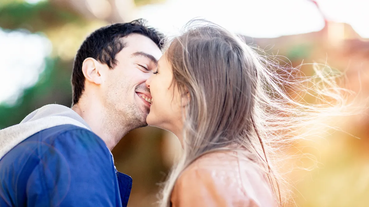 Couple étreint, les cheveux de la mariée flottant au vent, moment de tendresse et de bonheur lors de leur séance photo de mariage.
