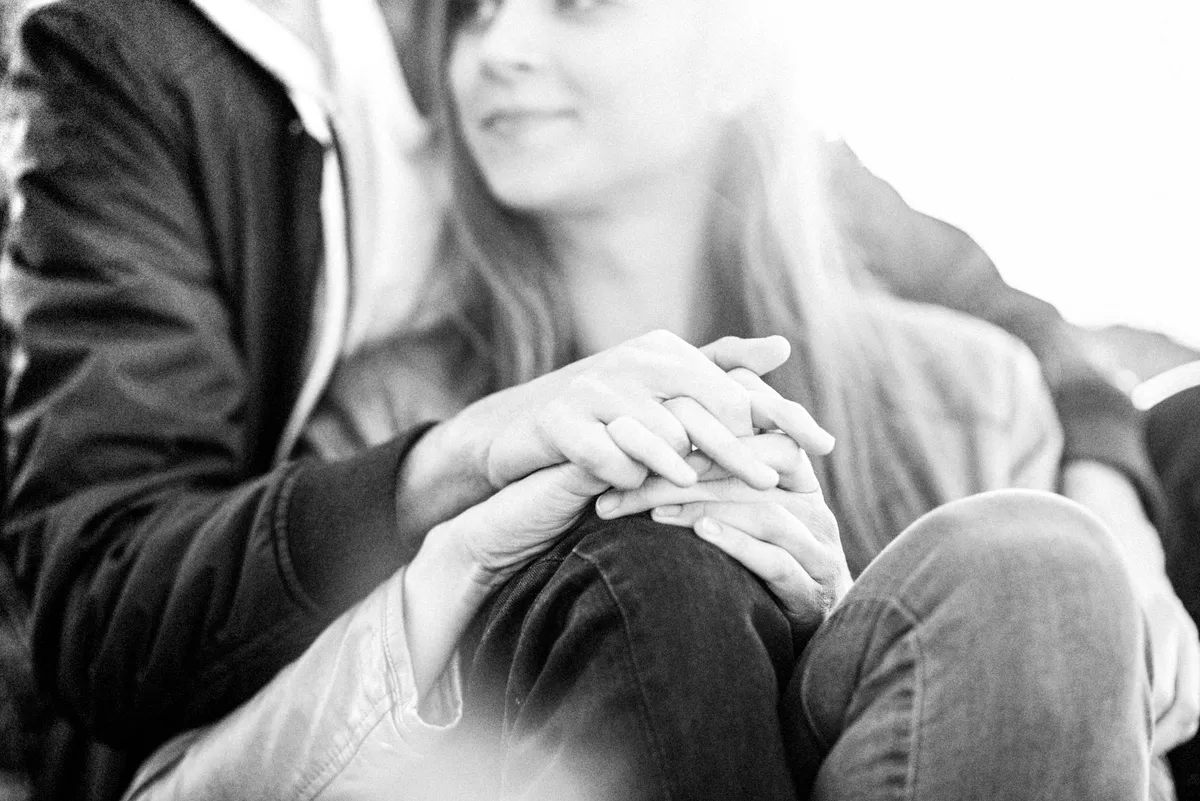 Deux mains se serrant, suggérant une intimité et un lien fort.