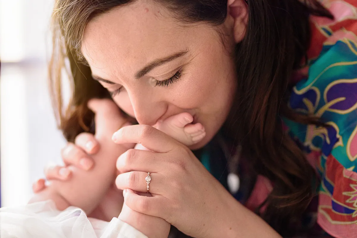 Femme enceinte priant avec un anneau de fiançailles sur la main, bébé au premier plan.