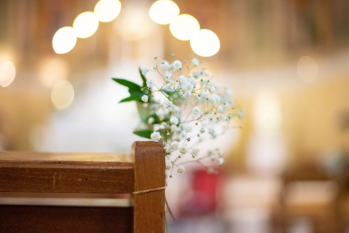 Un siège en bois dans une église avec des lumières douces.