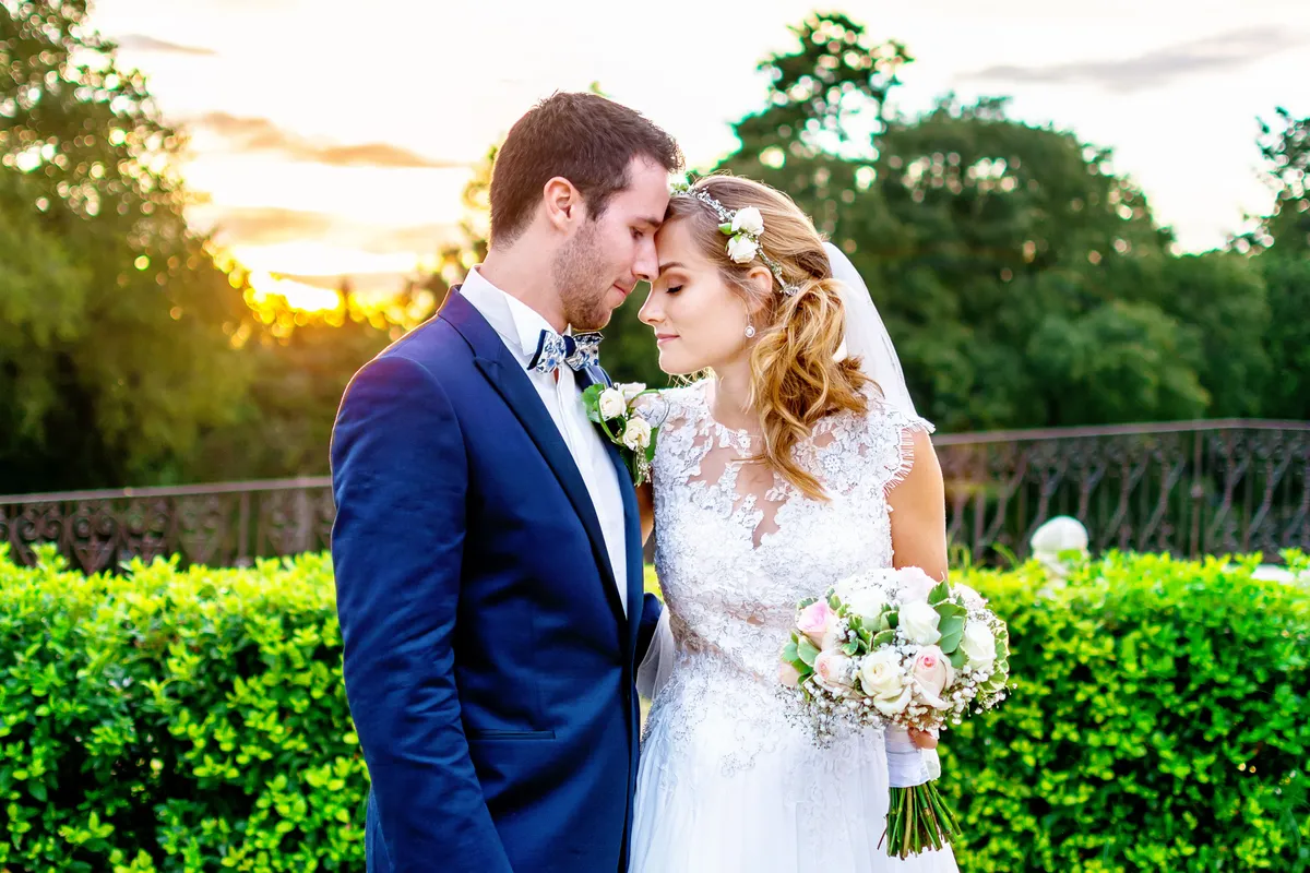 Mariage : les mariés se regardent tendrement dans un décor de verdure luxuriante.